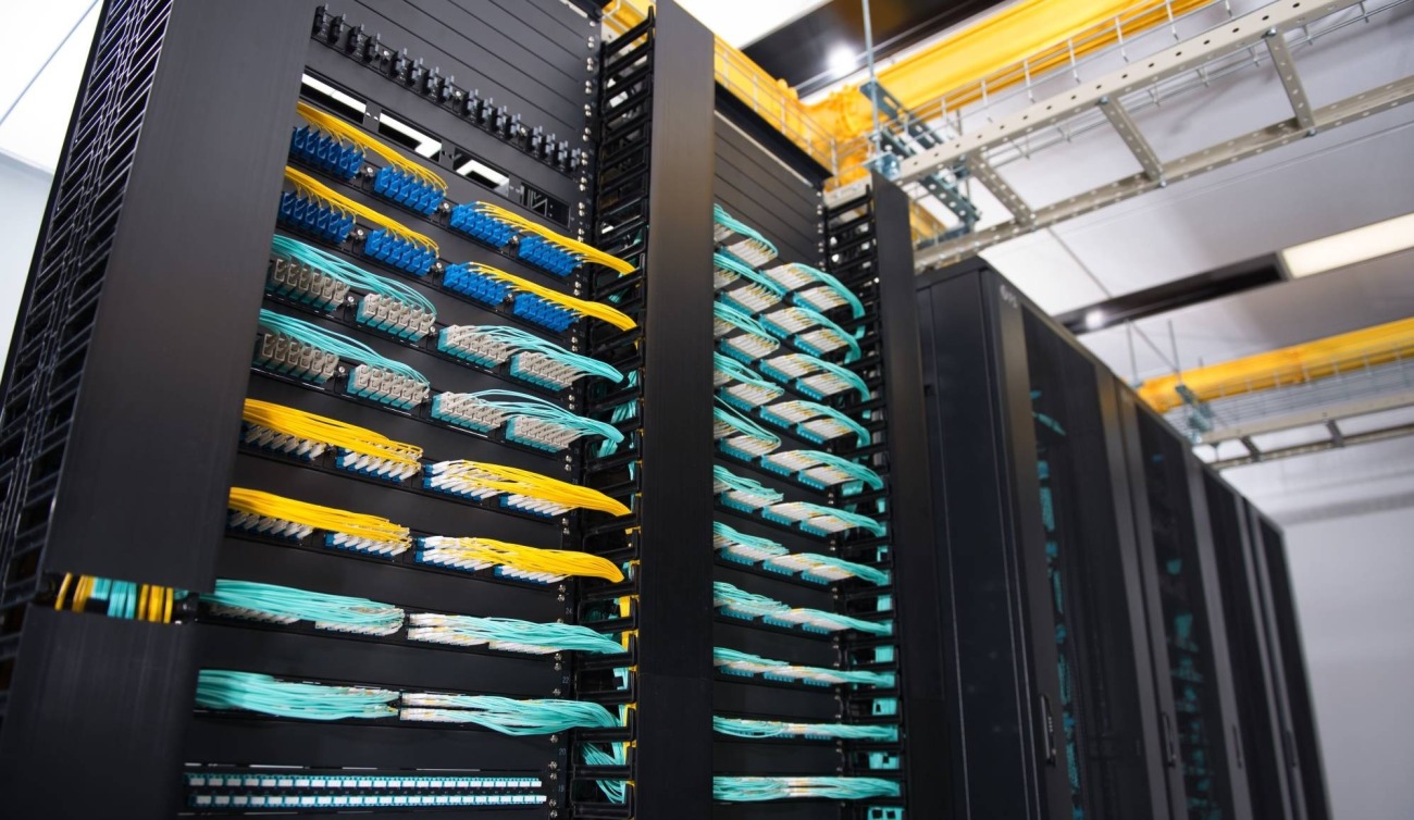 Datacenter com cabeamento estruturado e fibra óptica organizados em racks